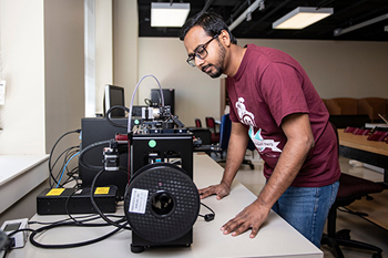 Abdullah Al Mamun, an MSU doctoral student, works to 3D print face shields