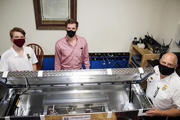 Students Justin Easley and Ryden Smith with the disinfectant box they built and Metro Ambulence Service's director