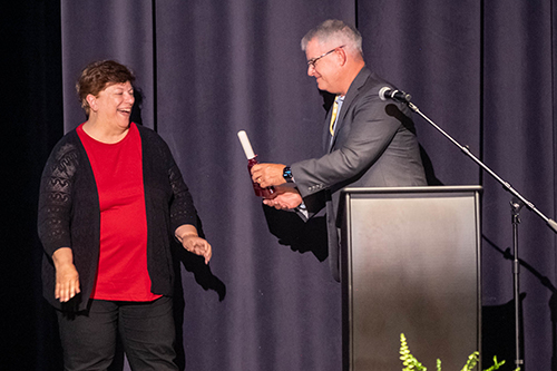 Jim Martin presenting cowbell to Lynne Clark