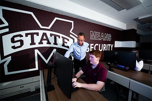 Associate Clinical Professor George Trawick, MSU cybersecurity program coordinator, looks on as computer science major Matthew Morgan of Hattiesburg works in Butler Hall's cybersecurity lab. Photo by Grace Cockrell